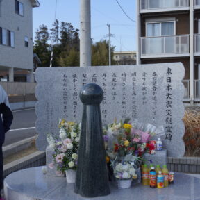 娘の愛梨さんらの名前が刻まれた慰霊碑の前で、語り部をしている母の美香さんの画像